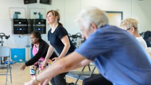 physical activity instructor conducting a chair-based-exercise class.