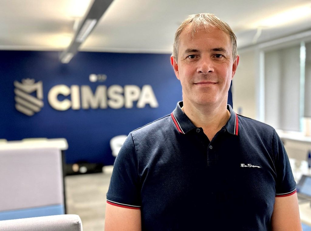 Spencer Moore in office smiling at camera